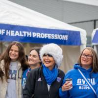 President Mantella smiles with a group of alumni at Reunion Row